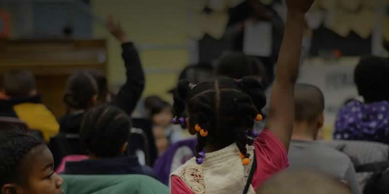 girl raising hand in classroom