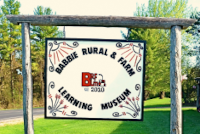 Babbie Museum front outdoor sign with grass and trees in the background