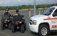 Two deputies on all terrain vehicles next to a Sheriff's Office van