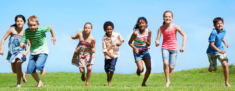 Children running on the grass with a blue sky background